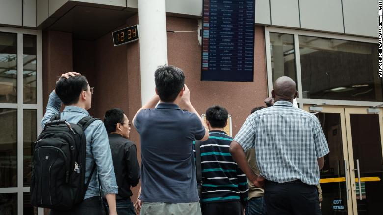 A Chinese group looks at the arrival flight schedule at Nairobi airport in Kenya on Sunday.